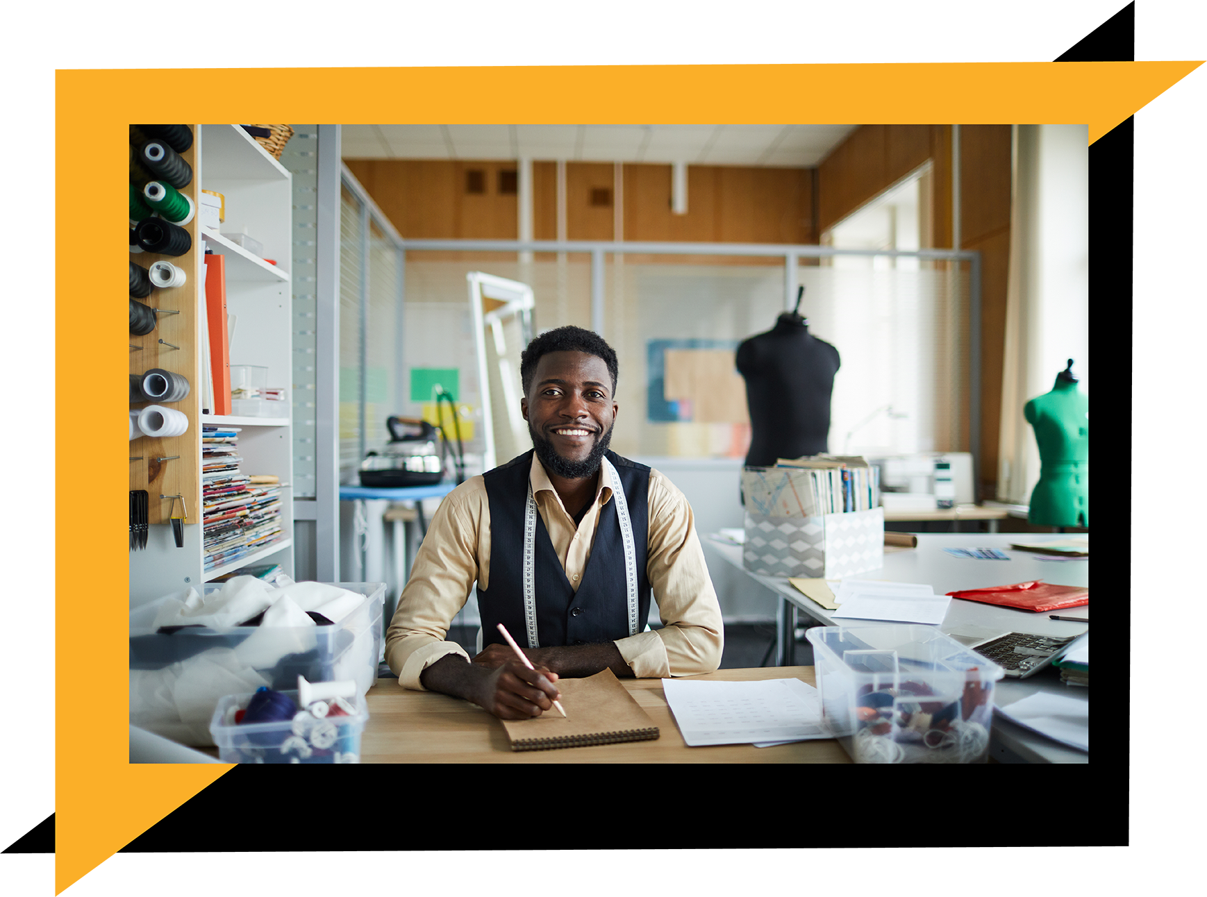 An African male designer sitting at a table sketching
